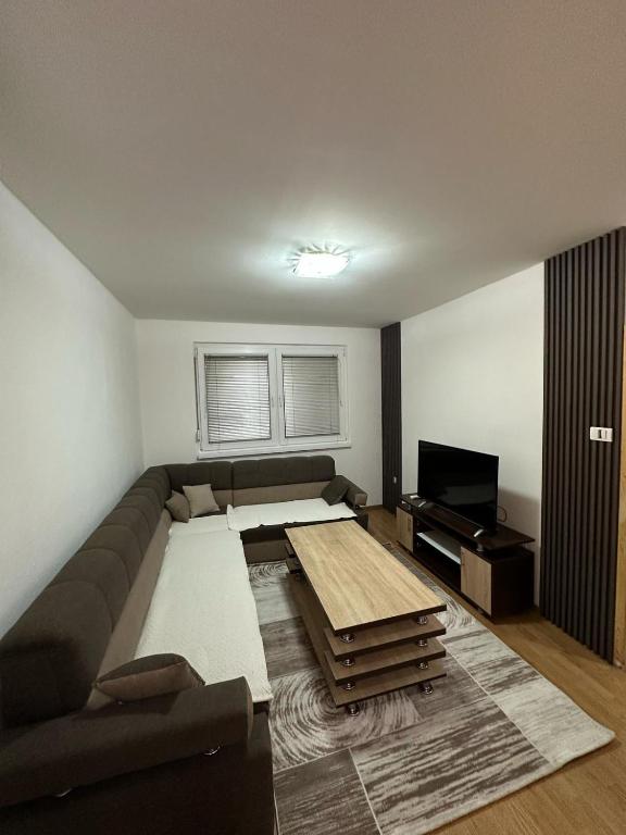 salon z kanapą i telewizorem w obiekcie Apartman Tajchi w Sarajewie