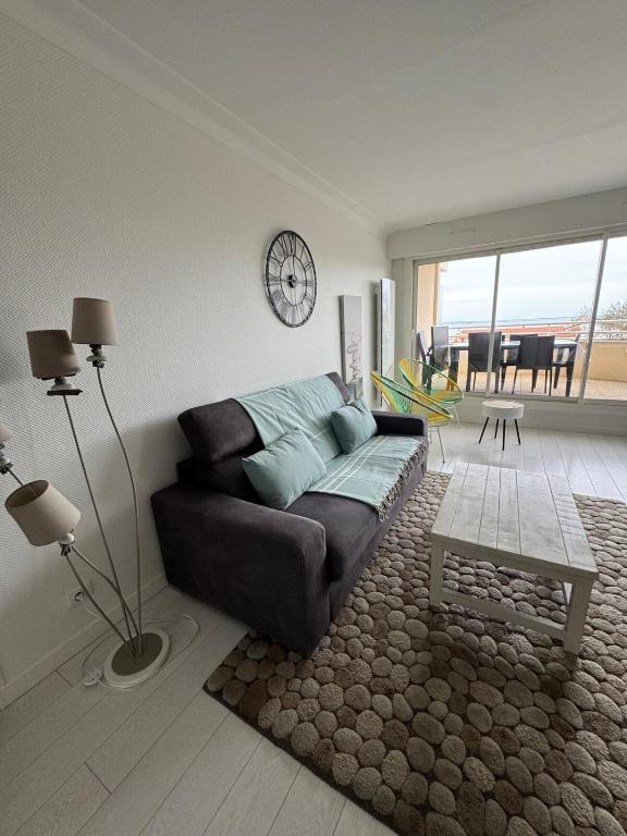 un salon avec un canapé et une table dans l'établissement Hyper centre Arcachon vu sur le bassin, à Arcachon
