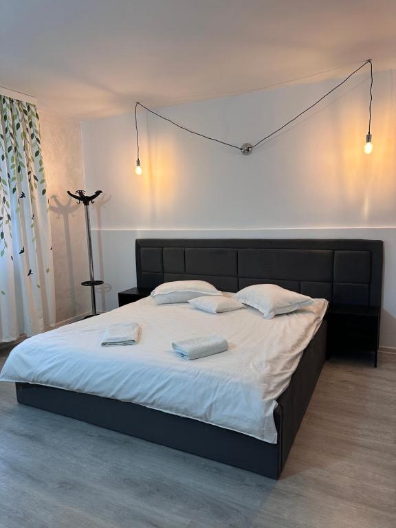 a bedroom with a large bed with two towels on it at Casa Valentino in Buşteni