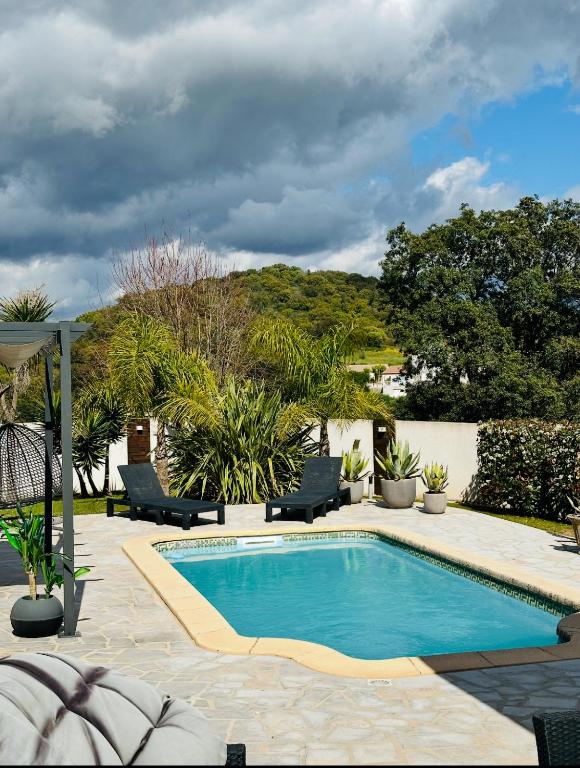 - une piscine dans une cour avec des chaises et des arbres dans l'établissement Villa avec piscine, à Alata