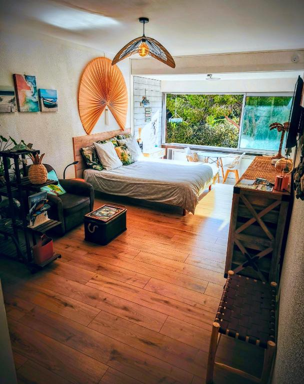 une chambre avec un lit et une grande fenêtre dans l'établissement Le Bali, à La Seyne-sur-Mer