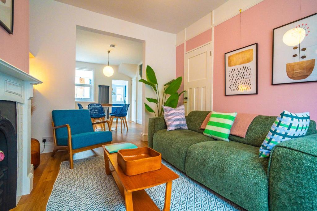 a living room with a green couch and a table at Ramsgate Family Cottage nr Beach -Harbour- Sleeps 4 - Garden - Parking on Street in Ramsgate