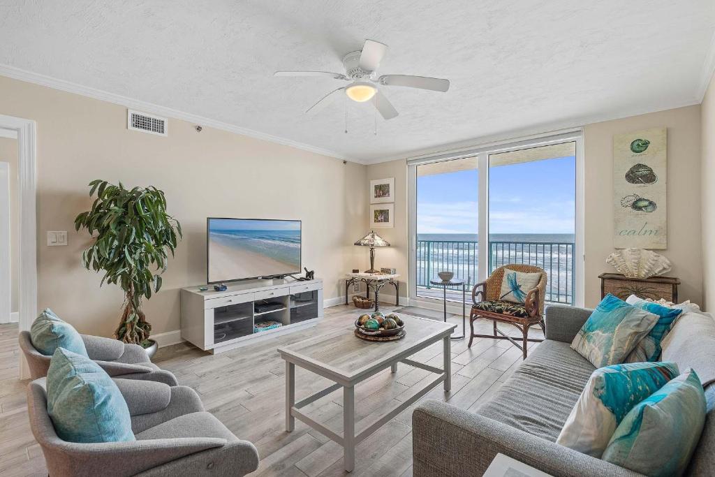 Una sala de estar con un sofá y un televisor. en DiMucci Tower 201, en Daytona Beach Shores