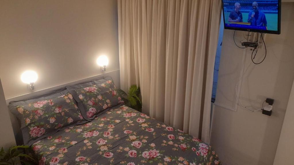 a bedroom with a bed and a flat screen tv at Studio climatizado, wifi no centro in Piratuba