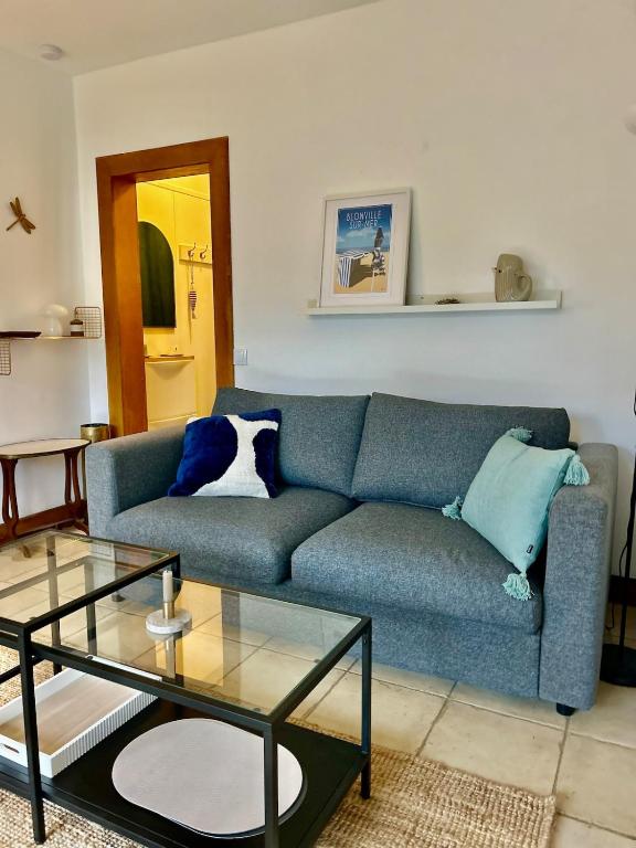 un salon avec un canapé bleu et une table en verre dans l'établissement Havre de paix, à Blonville-sur-Mer