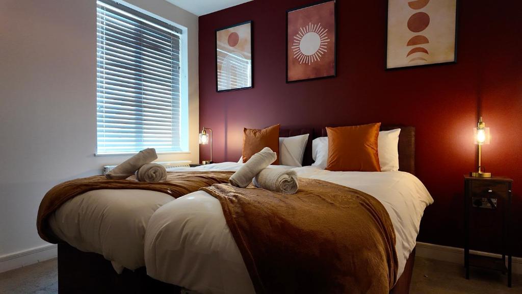 two beds in a bedroom with red walls at City Center 1 Bed Flat in Peterborough