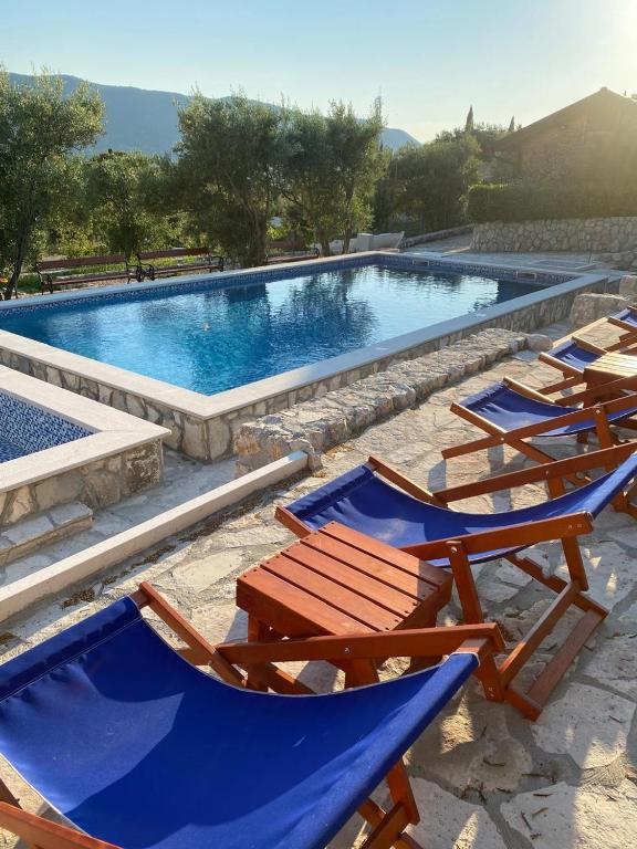 a group of chairs sitting next to a swimming pool at Jasmine Apartment in Herceg-Novi