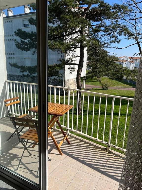 d'une table en bois et d'un banc sur un balcon. dans l'établissement Appartement 3 pièces Royan, à Royan