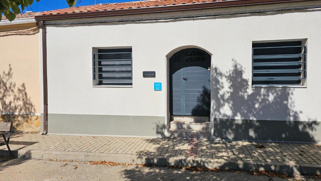 a white building with a door and a bench at la casita in Almazán