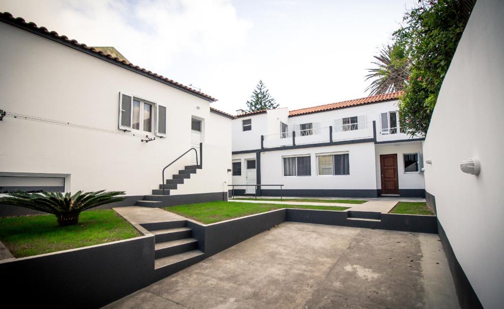 un patio de una casa con dos edificios blancos en Casa Mãe Deus - House Azores en Ponta Delgada