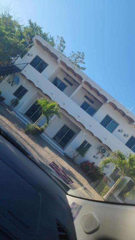 a car parked in front of a large white building at Recidencial Pacifico in Rincon de Guayabitos
