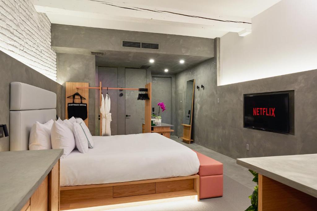 a bedroom with a white bed and a kitchen at David Hotel in Montréal