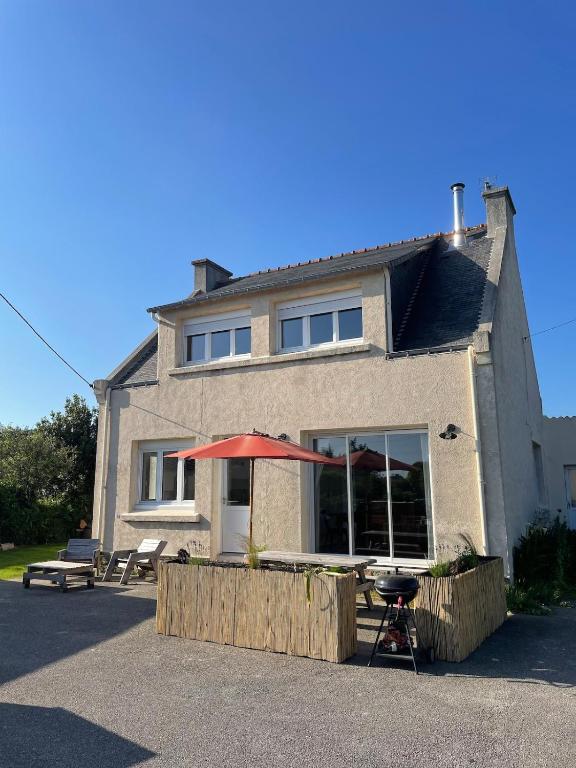 une maison avec une table et un parasol devant elle dans l'établissement Maison lumineuse, 3 chambres, avec jardin, à Quiberon