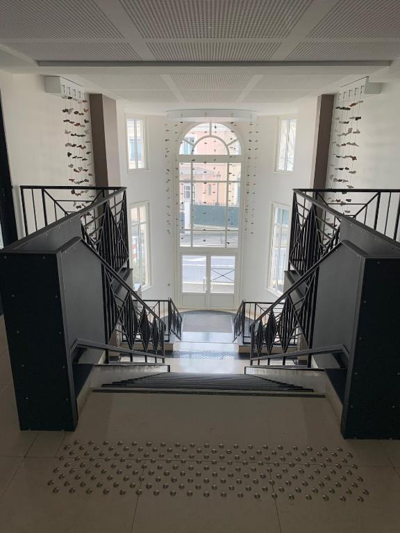 - un escalier dans un bâtiment doté d'une grande fenêtre dans l'établissement Le Capitole, à Puteaux