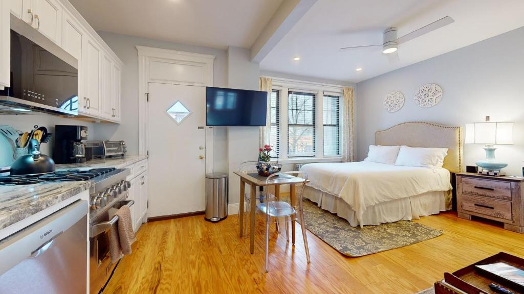 a kitchen and a bedroom with a bed in a room at Renovated, Spacious Studio, Near Bc, Bu, Porch in Boston