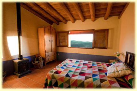 1 dormitorio con 1 cama y chimenea en El Nido de La Collalba, en Cabañas del Castillo