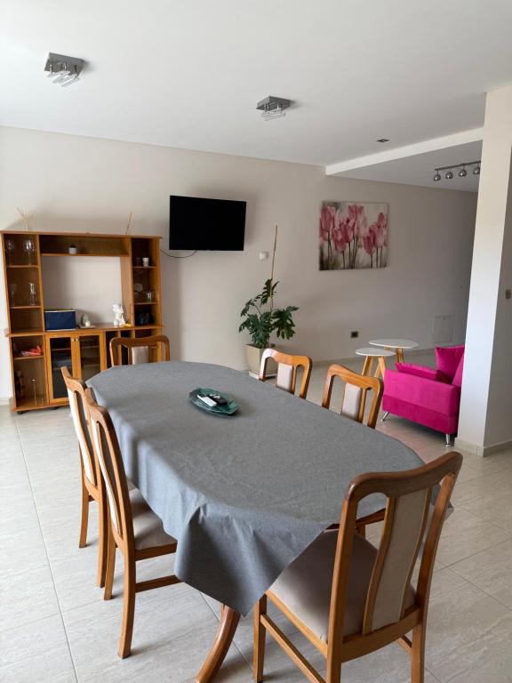 een woonkamer met een tafel met stoelen en een roze bank bij Departamento Luz in Plottier
