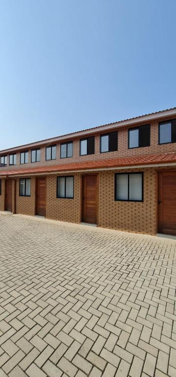 a brick building with windows and a brick driveway at Loft 01 in Tubarão
