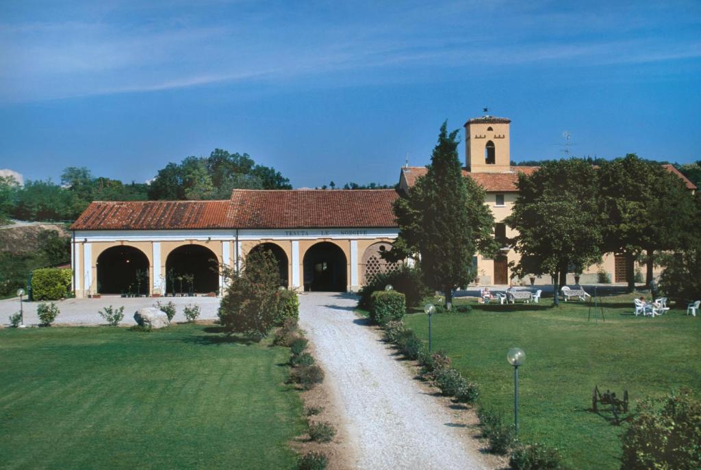 duży budynek z wieżą zegarową na polu w obiekcie Tenuta Le Sorgive Agriturismo w mieście Solferino