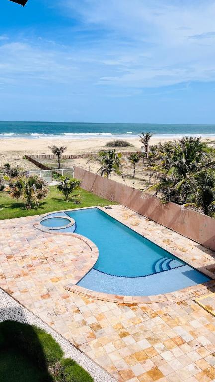 a swimming pool with the beach in the background at Todo Azul do Mar in Taíba