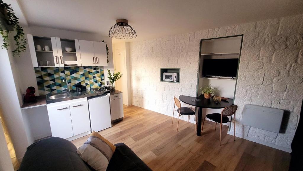 un salon avec une table et une cuisine dans l'établissement Studio Neuf et Design, à Saint-Laurent-sur-Sèvre