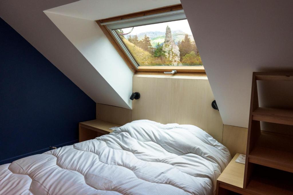 a bed in a room with a window at Gîte Roche Pointue - Ski - Domaine in Villard-de-Lans