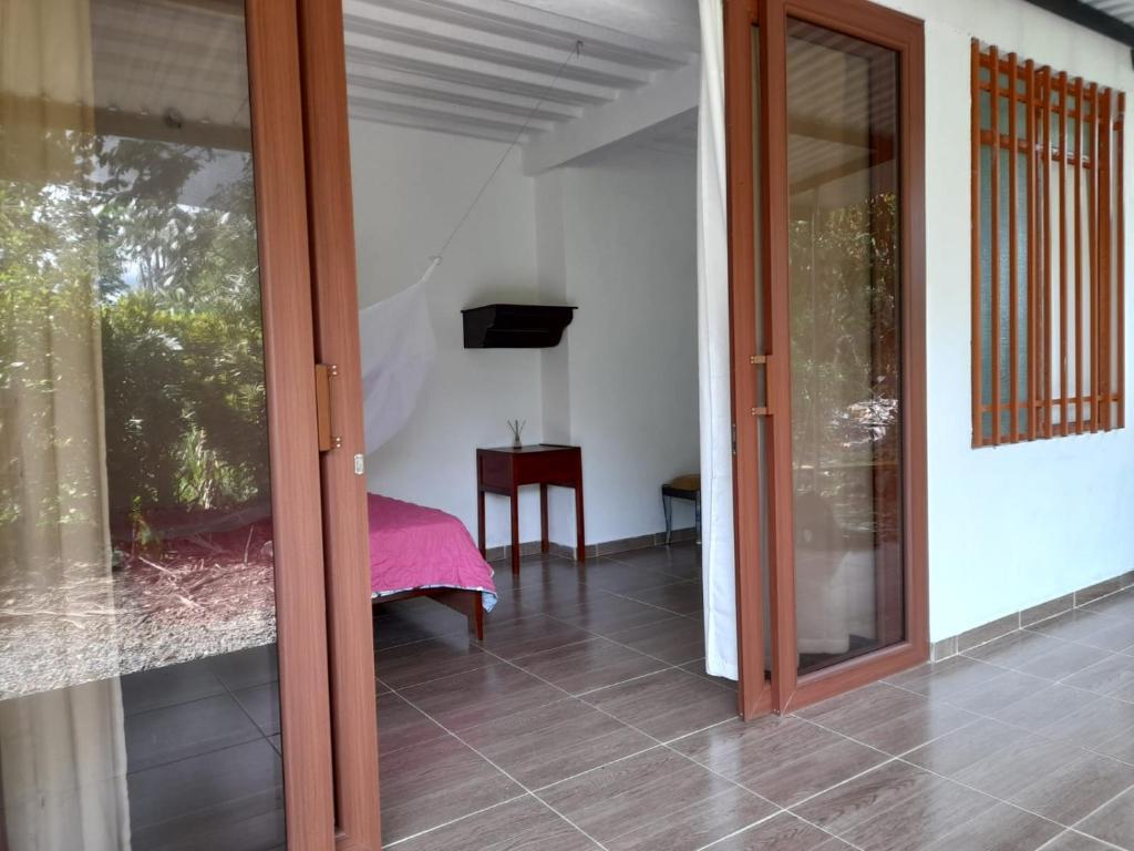 a room with a sliding glass door and a table at Hostal Ariantiy in Pepino