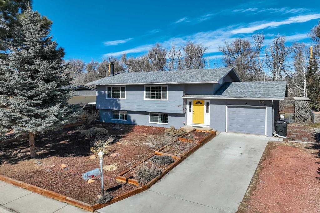 una casa con una puerta amarilla y un camino de entrada en Colors of Colorado Parks & Trails Dog-Friendly, en Fountain
