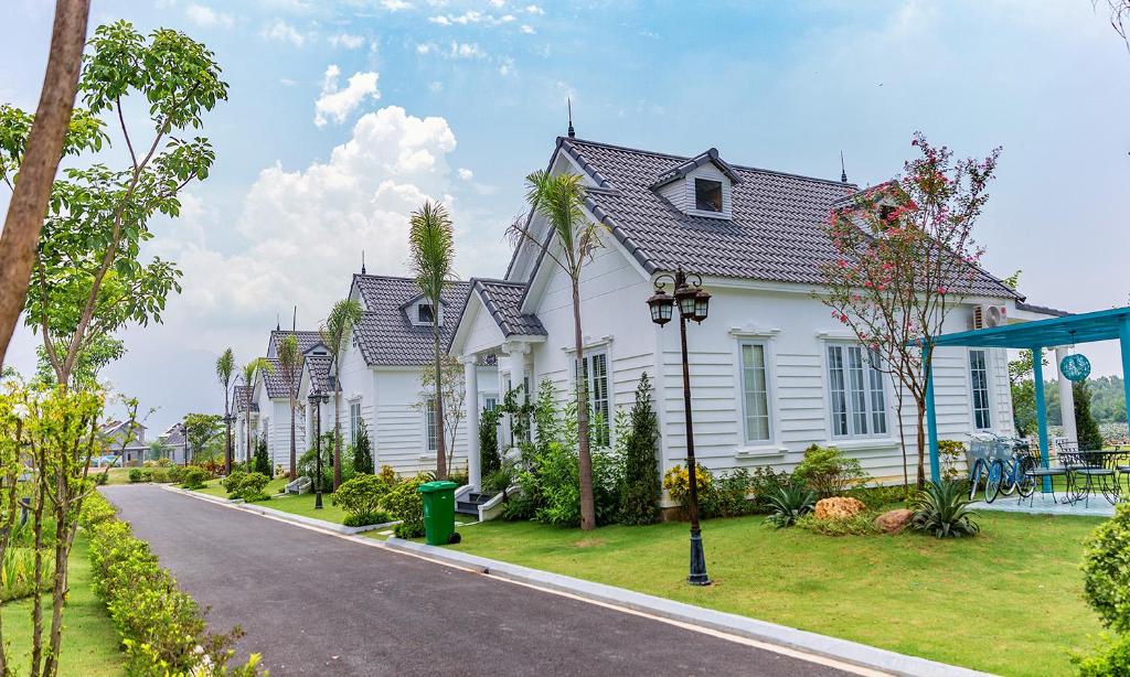 a row of white houses on a street at Vườn Vua Resort & Villas in Ðồng Phú