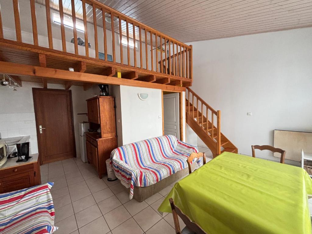 une chambre avec un lit vert et un escalier dans l'établissement Maison au bourg de Saint-Mathurin, proche commerces, à 10km des plages des Sables d'Olonne, pour 2 pers. - FR-1-197-546, à Saint-Mathurin