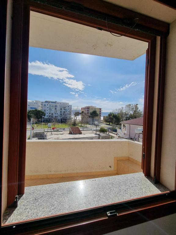 a large window with a view of a city at Villa BASHLLARI A&B appartamenti di fronte al mare in Vlorë