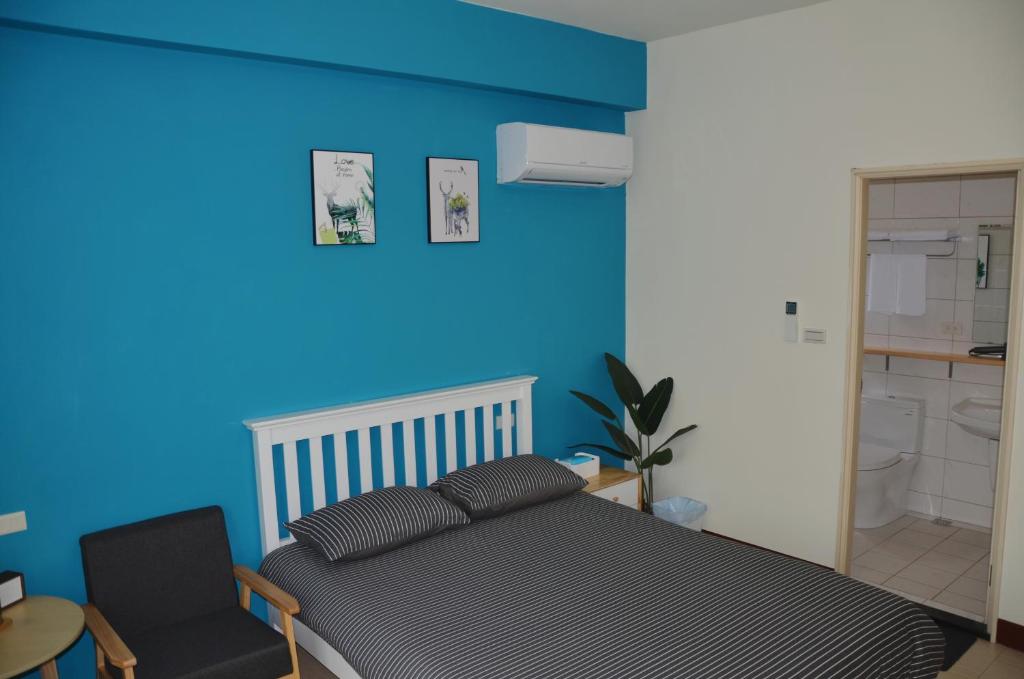 a blue bedroom with a bed and a chair at Kinmen Fujian Homestay in Tung-chou