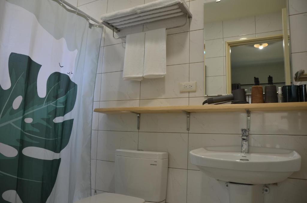 a bathroom with a toilet and a sink and a mirror at Kinmen Fujian Homestay in Tung-chou