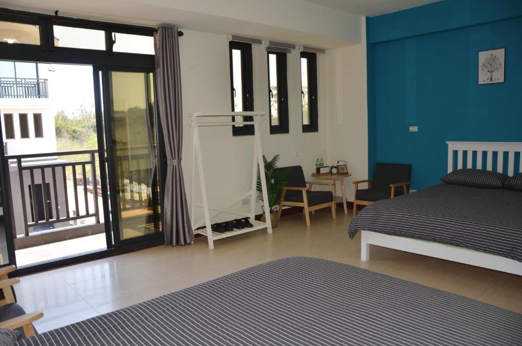 a bedroom with blue walls and a bed and a table at Kinmen Fujian Homestay in Tung-chou