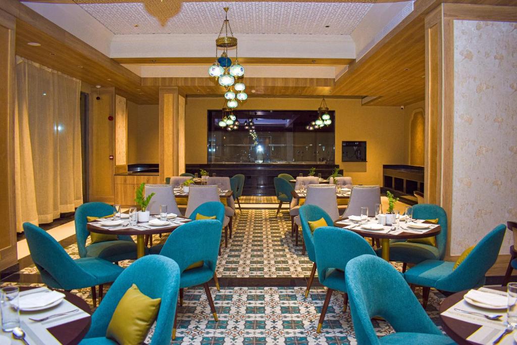 斋浦尔Urban Suites by BluSalzz, Jaipur - Rajasthan的一间有桌子和蓝色椅子的餐厅