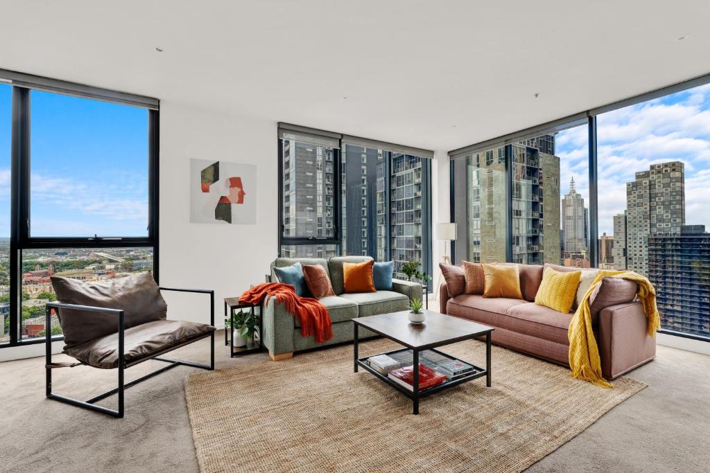 a living room with a couch and chairs and large windows at Zen Grand 3 Bedroom Residences 120m2 with up to 7 Separate Beds in Melbourne