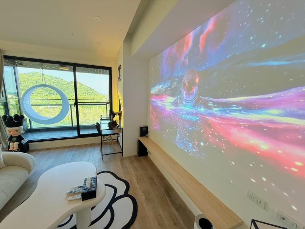 a living room with a large projection screen on the wall at 光嶼海溫泉海景無邊際泳池豪華套房 in Hsin-hsing