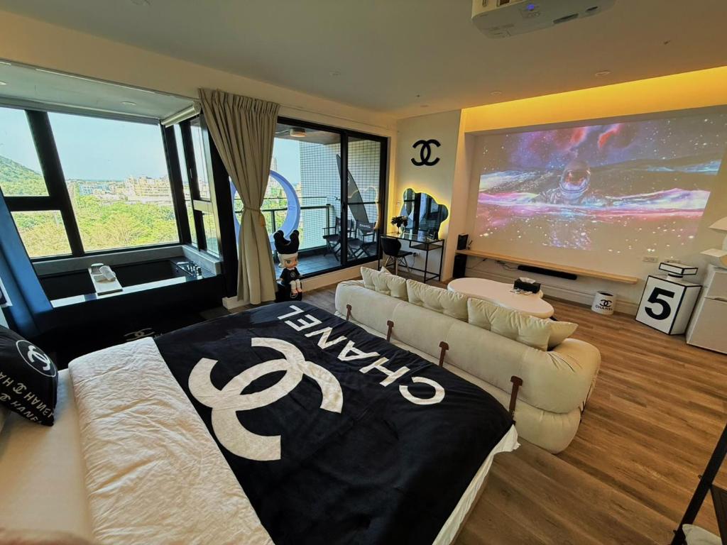 a living room with a couch and a large tv at 光嶼海溫泉海景無邊際泳池豪華套房 in Hsin-hsing