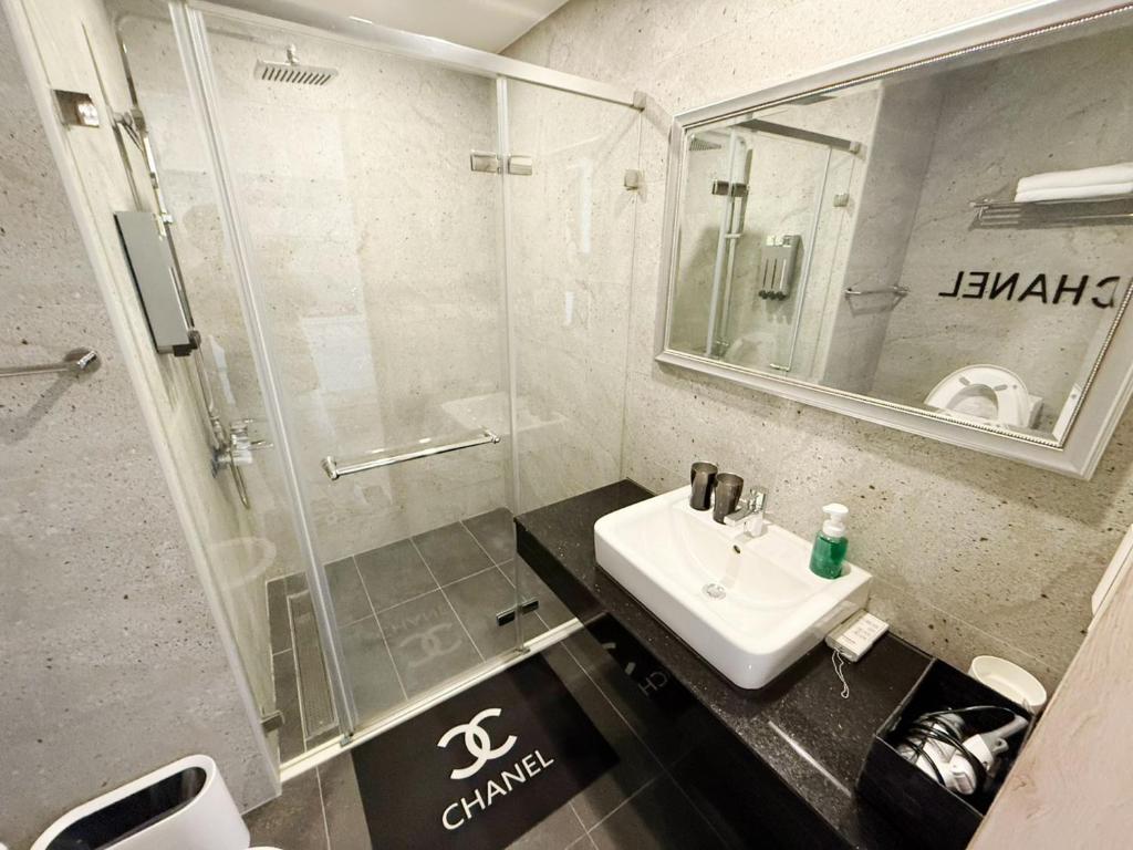 a bathroom with a sink and a shower at 光嶼海溫泉海景無邊際泳池豪華套房 in Hsin-hsing