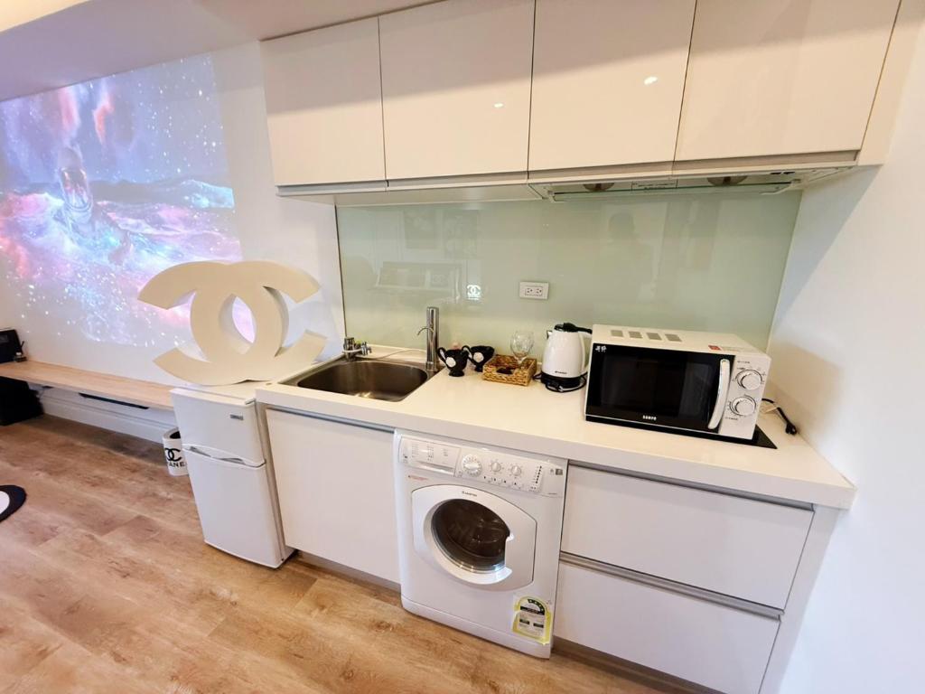 a kitchen with a washing machine and a sink at 光嶼海溫泉海景無邊際泳池豪華套房 in Hsin-hsing