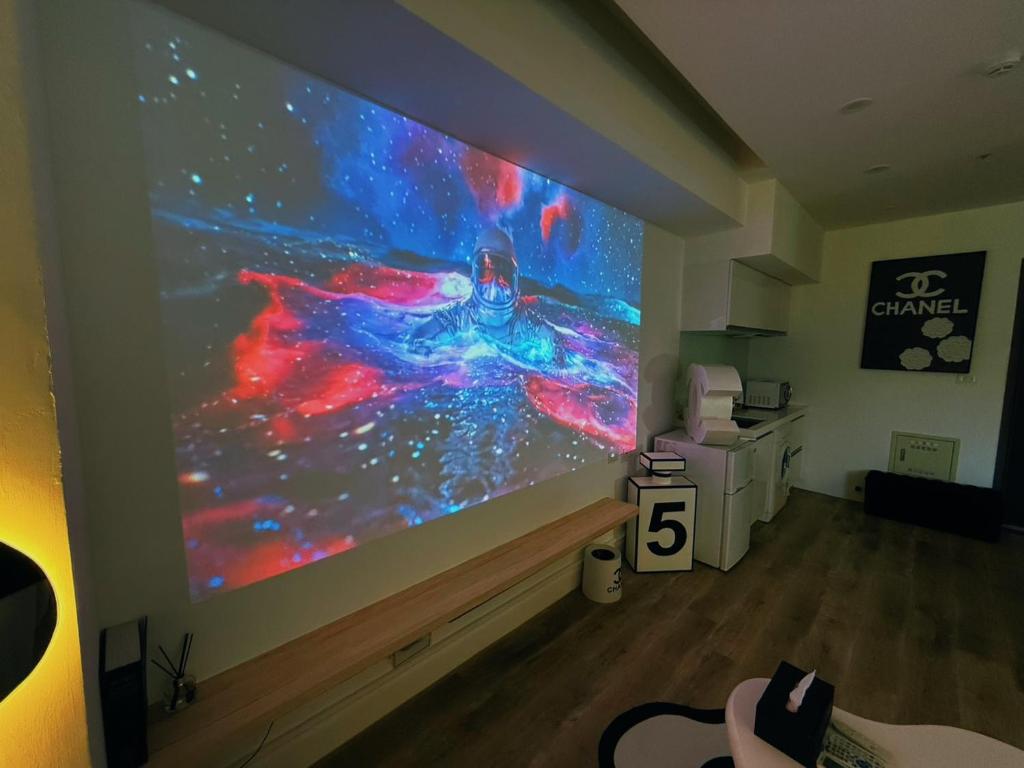 a large projection screen on a wall in a room at 光嶼海溫泉海景無邊際泳池豪華套房 in Hsin-hsing