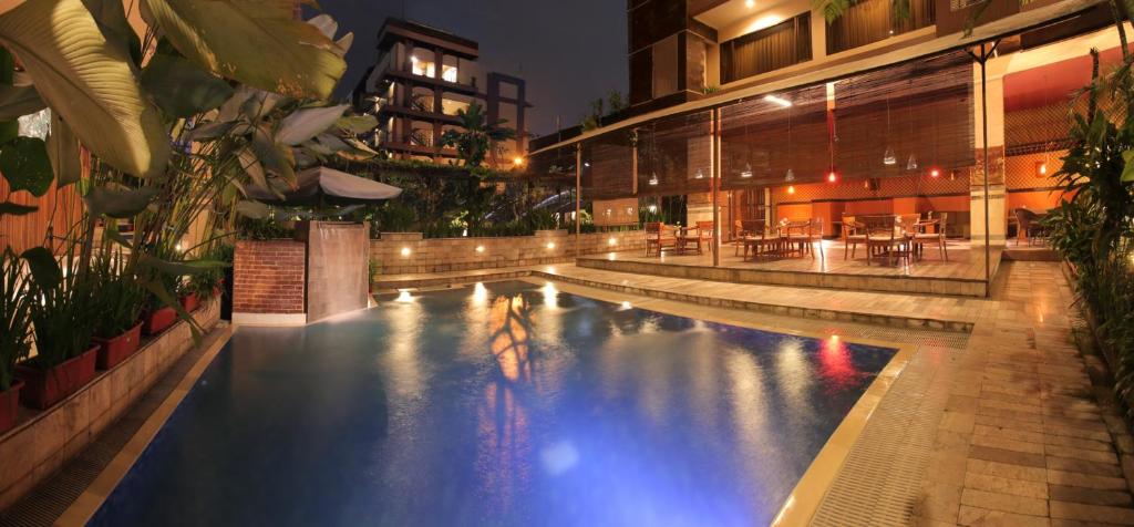 a large swimming pool in a building at night at Bali World Hotel in Bandung