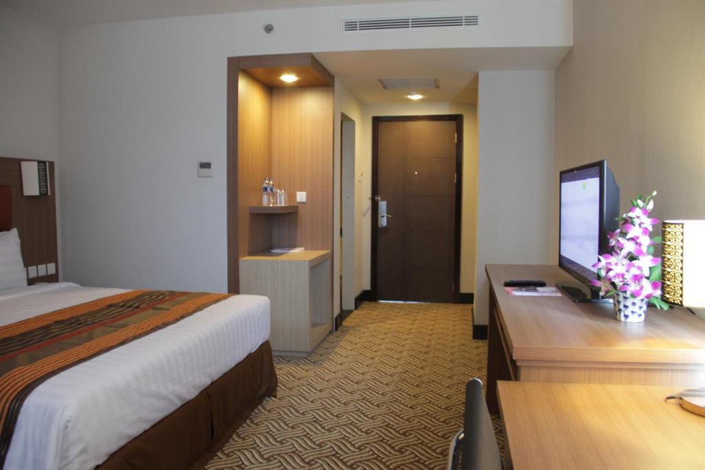 Postel nebo postele na pokoji v ubytování Cavinton Hotel Malioboro Yogyakarta