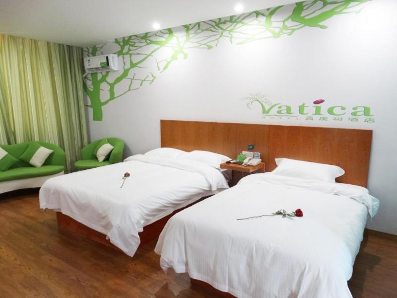 a hotel room with two beds with white sheets at Vatica ShangDong Heze Mudan Road Shangri-La Square Hotel in Heze