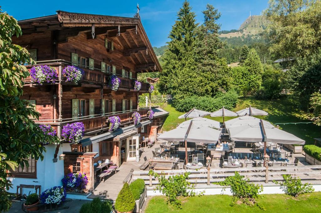 eine Luftansicht des Gasthofs mit Tischen und Sonnenschirmen in der Unterkunft Landhotel Vordergrub in Kitzbühel