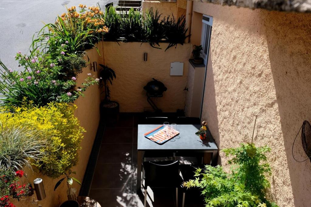 an overhead view of a patio with a table and plants at Collioure, appartement clair, terrasse et parking in Collioure