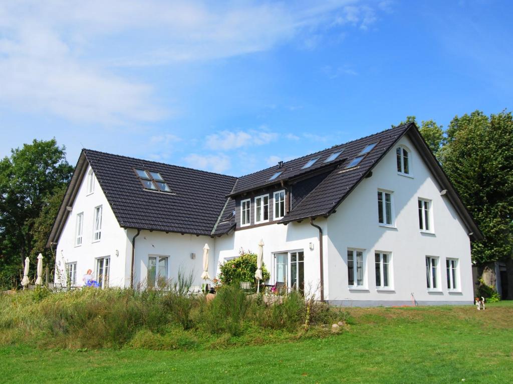 a white house with a black roof at Ferienwohnung Hiddensee Hitthim in Kloster