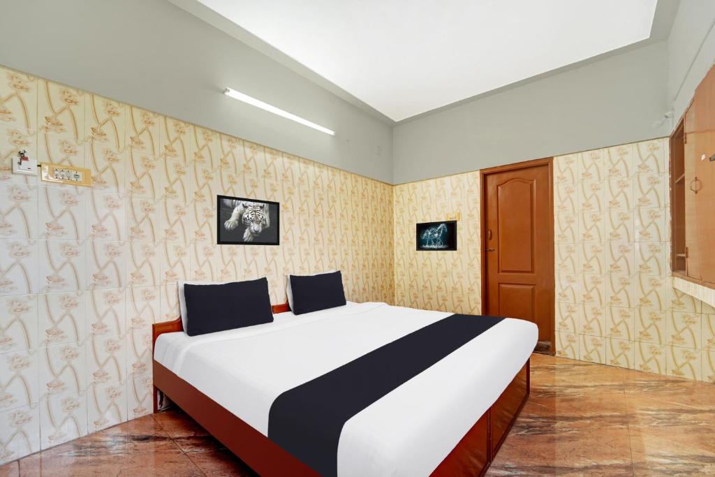 um quarto com uma cama grande em um quarto em Super Hotel O Tiruppur Near Railway station em Tiruppūr