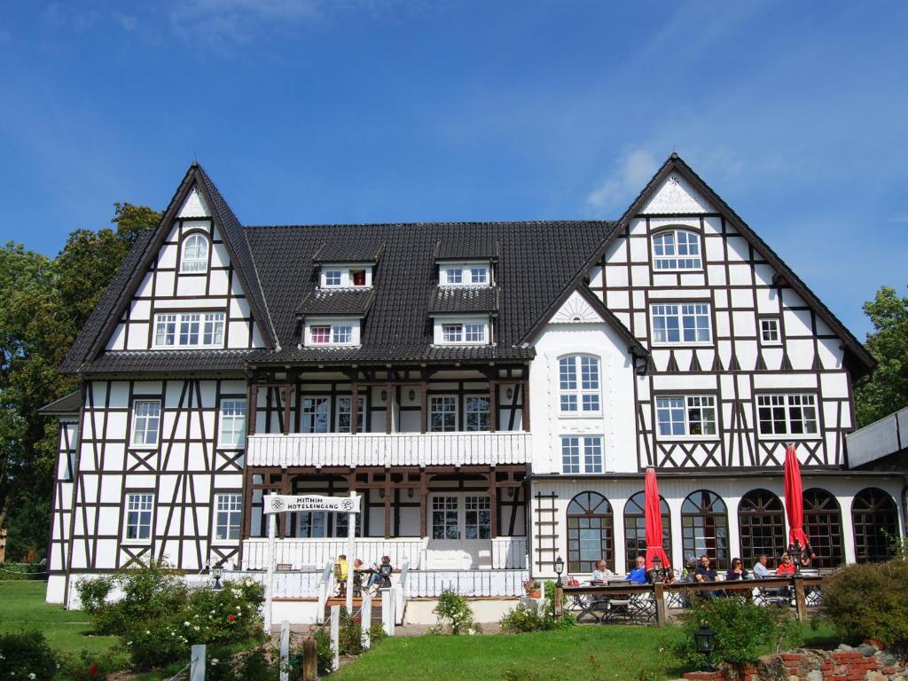 una casa grande con gente parada fuera de ella en Hotel Hiddensee Hitthim en Kloster