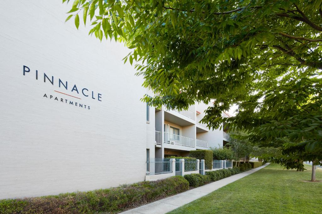un edificio blanco con un cartel en el costado en Pinnacle Apartments, en Canberra